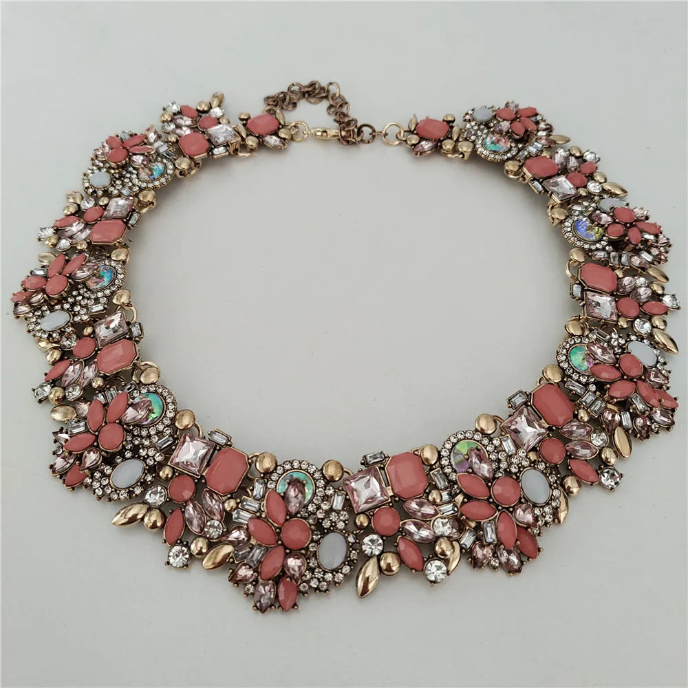 Decorative necklace with pink and gold stones on a light gray background