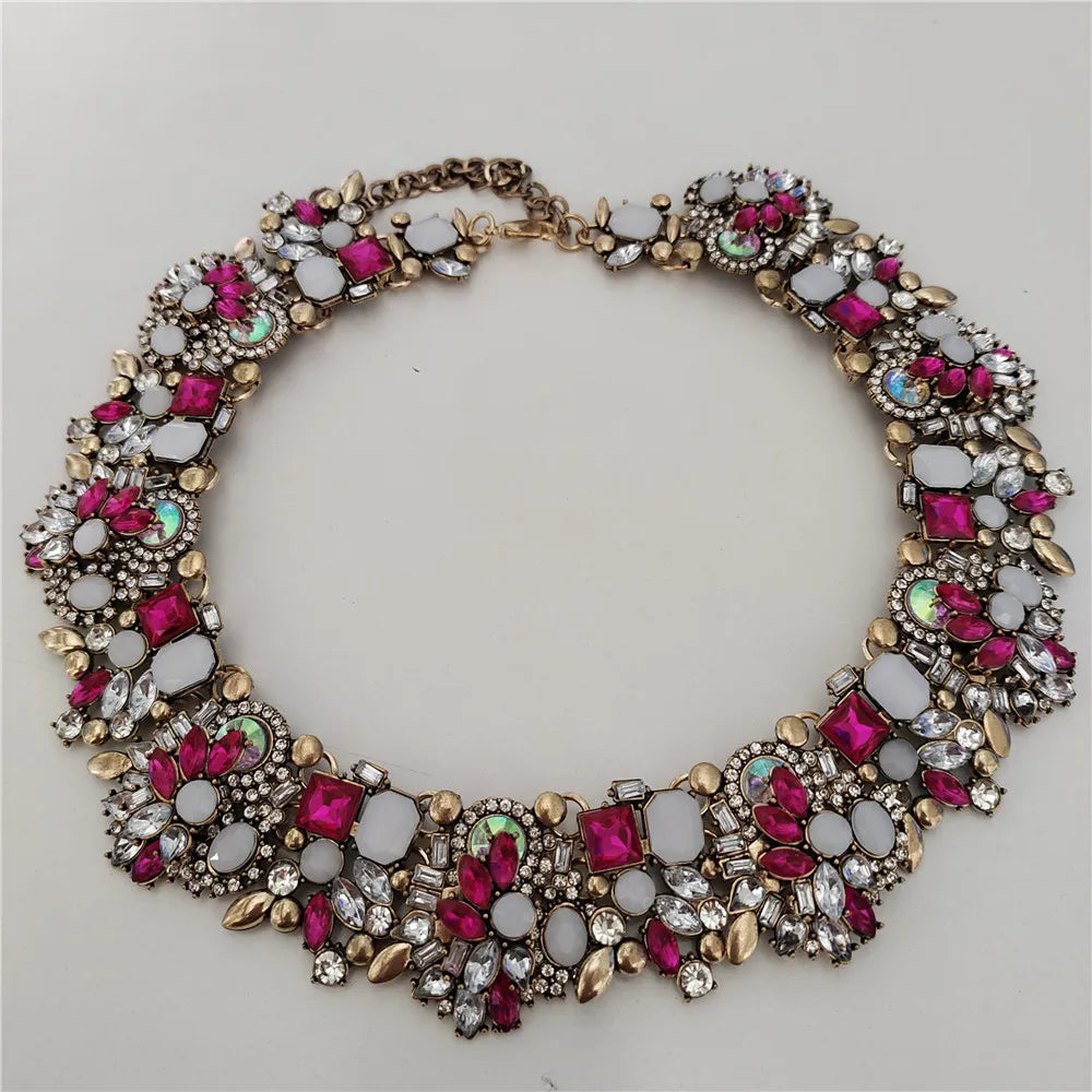 Decorative necklace with colorful gemstones on a light gray background