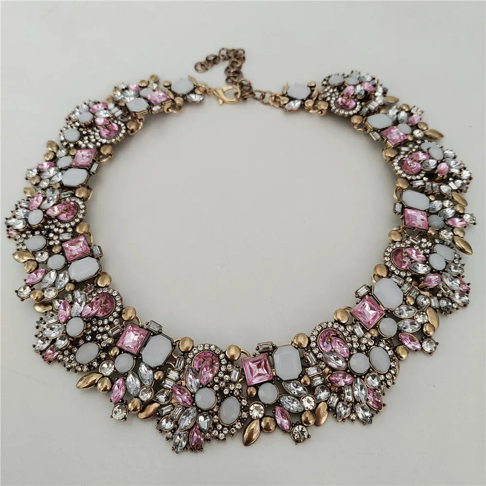 Decorative necklace with pink and clear stones on a light gray background