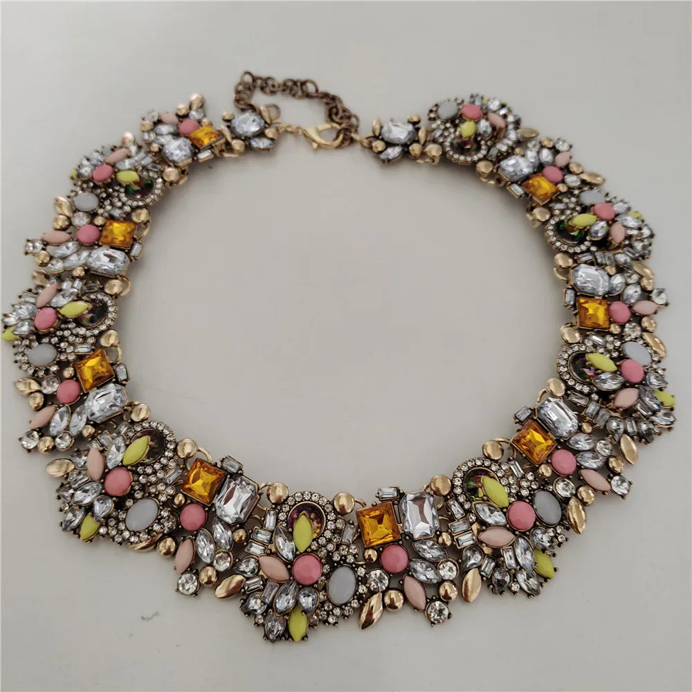 Decorative necklace with multicolored gemstones on a light gray background